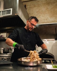 Chef Ramiro Oraindi tossing pasta in the Fort Consolation kitchen