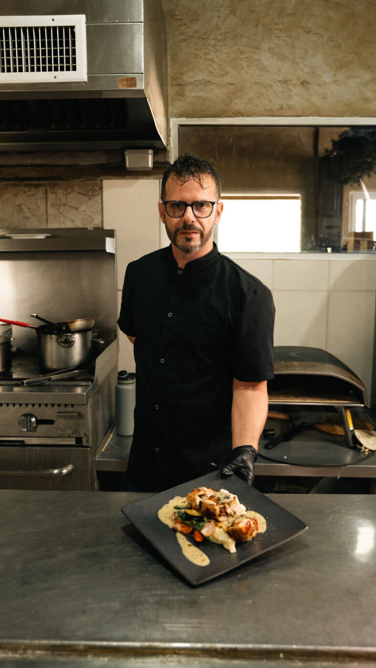 Chef Ramiro Oraindi in the Fort Consolation kitchen with a finished plate