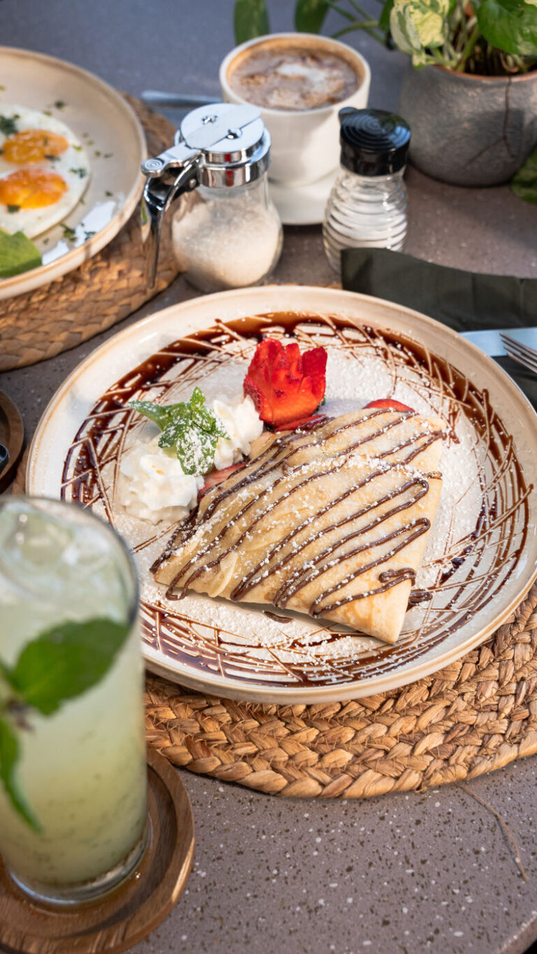 Crepe with chocolate sauce, cream and fresh strawberries