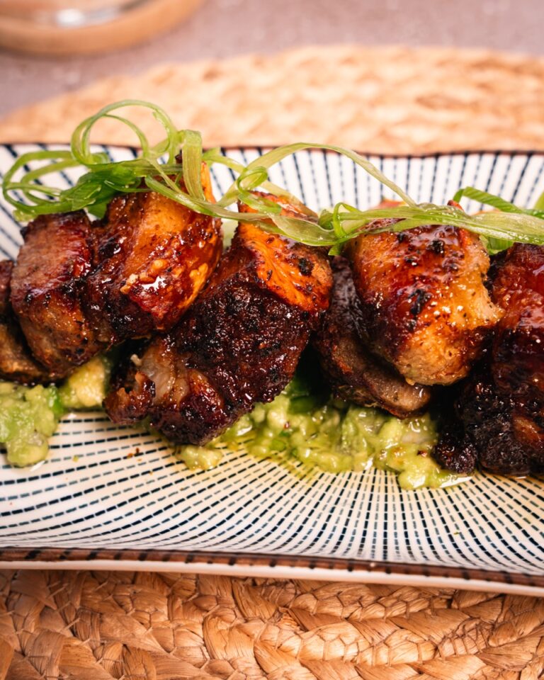 Crispy pork glazed with jalapeno hot honey on a bed of guacamole
