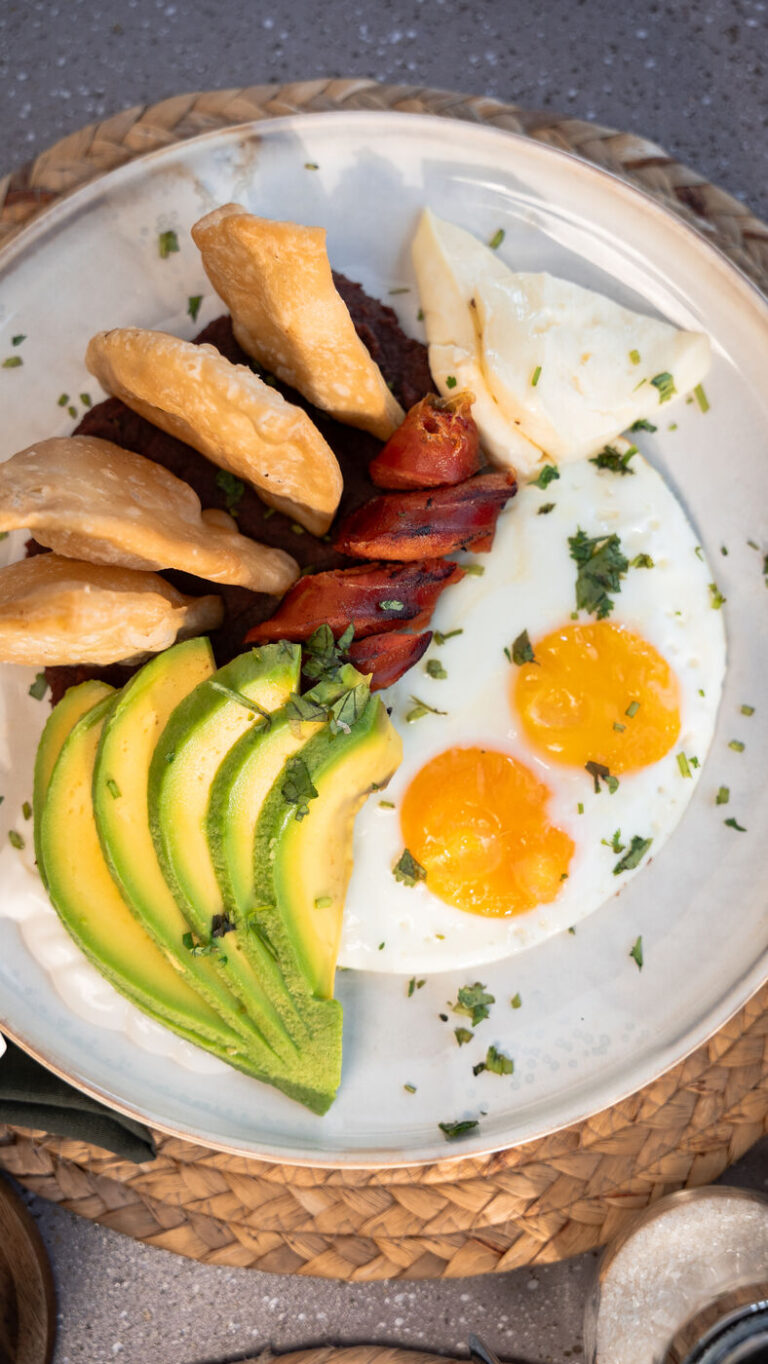 El Catracho breakfast plate with fried eggs, avocado, chorizo and pastry fritters