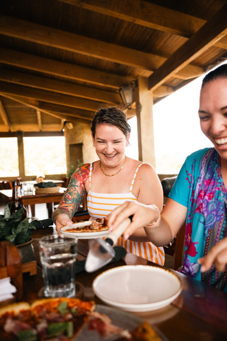 Friends laughing over lunch at Fort Consolation