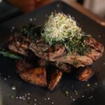 Grilled beef churrasco with chimichurri, baked potato and vegetables at Fort Consolation