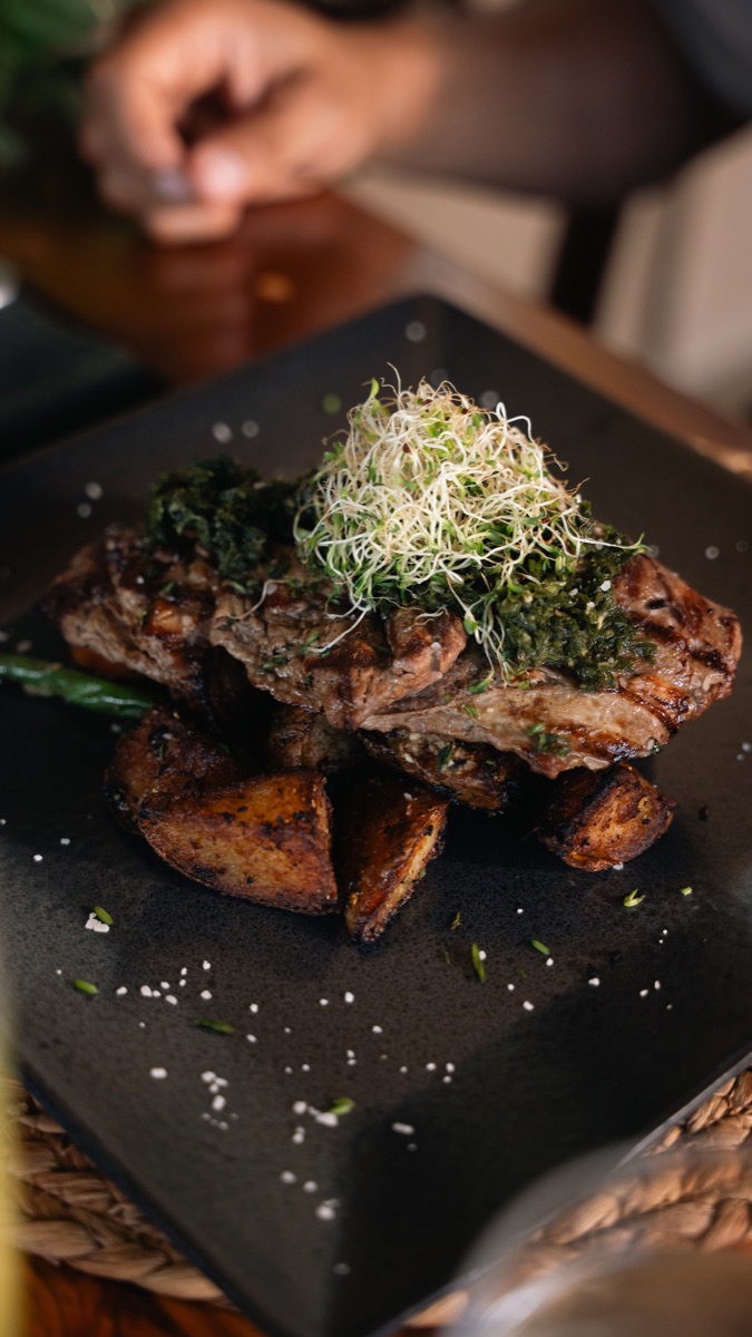 Grilled beef churrasco with chimichurri, baked potato and vegetables