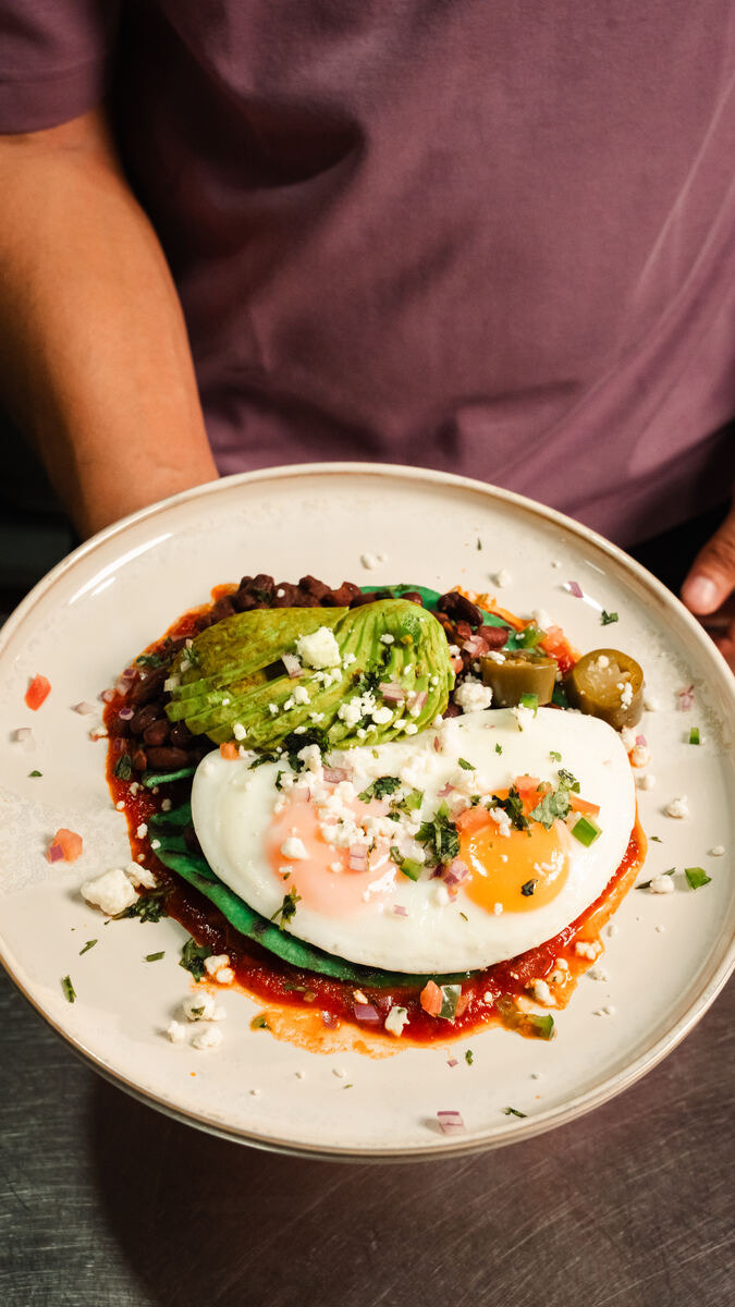 Huevos rancheros with fried eggs, beans, avocado, salsa and crumbled white cheese