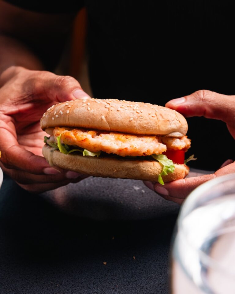 Shrimp patty burger in a sesame bun with lettuce and tomato