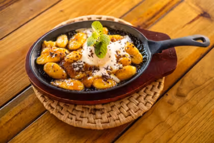 Skillet of caramelised plantains with ice cream and fresh mint